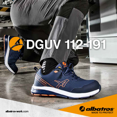 Ein Paar blaue Albatros VIGOR 2 IMPULSE BLUE LOW S3S ESD FO HRO SR Sicherheitsschuhe wird in einer industriellen Umgebung getragen, während sich eine Person kniend abstützt.