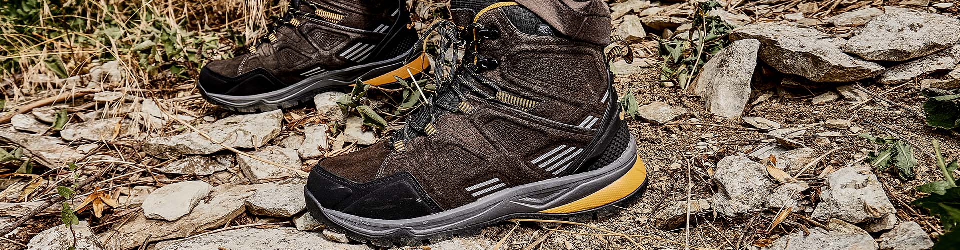 Auf dem Bild ist ein Paar Albatros Trekking-Schuhe auf einem steinigen, naturbelassenen Untergrund zu sehen.